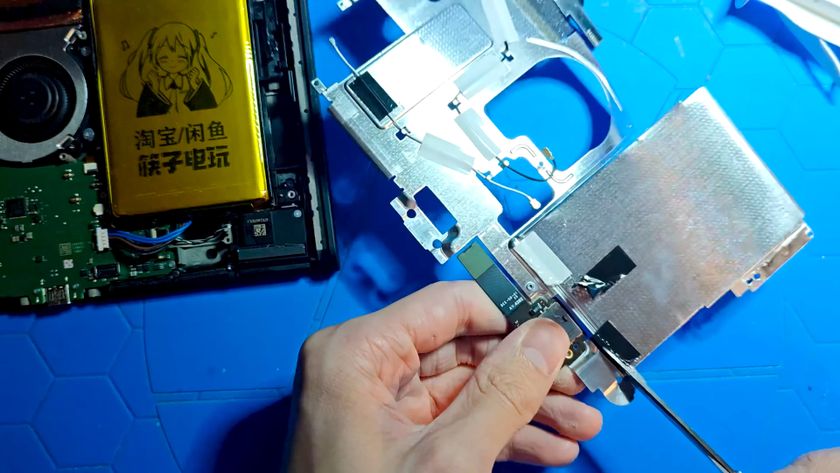 A still from a YouTube video showing a disassembled Nintendo Switch 2 being cut apart with a pair of scissors