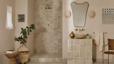 A neutral bathroom with patterned tiles in the shower nook, vanity, and floor