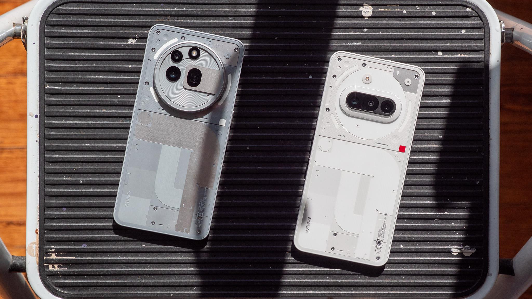 Comparing the transparent backs of the grey Nothing Phone 3a Pro with the white Nothing Phone 3a