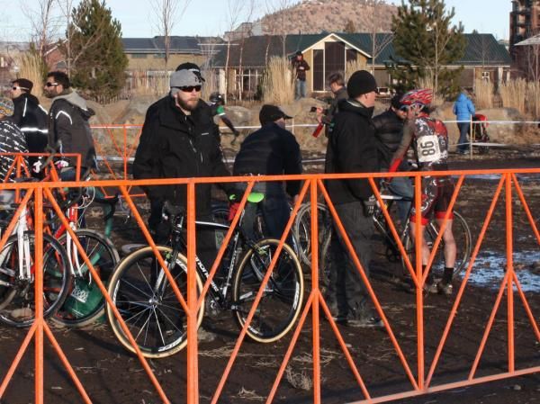Jeremy Powers' (Cannondale-Cyclocrossworld.com) crew waits for him to come into the pits with one man waiting to catch the incoming bike and another holding the replacement in position.