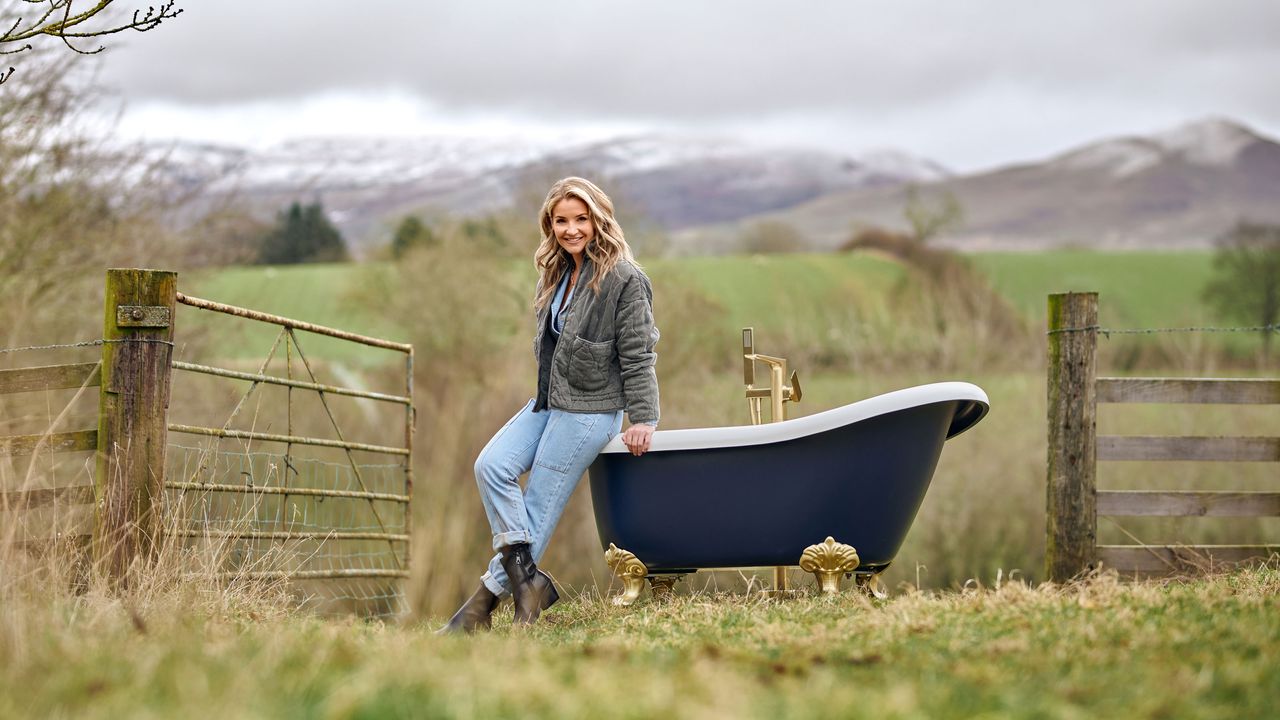 Helen Skelton standing in a field beside a bath tub 