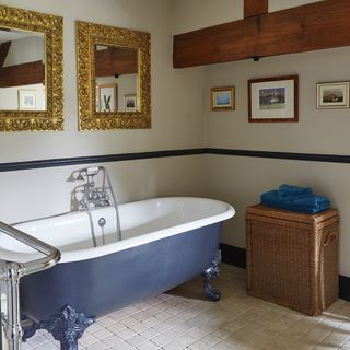 bathroom with bathtub with blue colour and mirror with golden frame