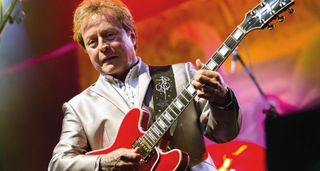 Rick Derringer looks sharp in a silver suit as he plays a cherry red Gibson Custom ES-355.