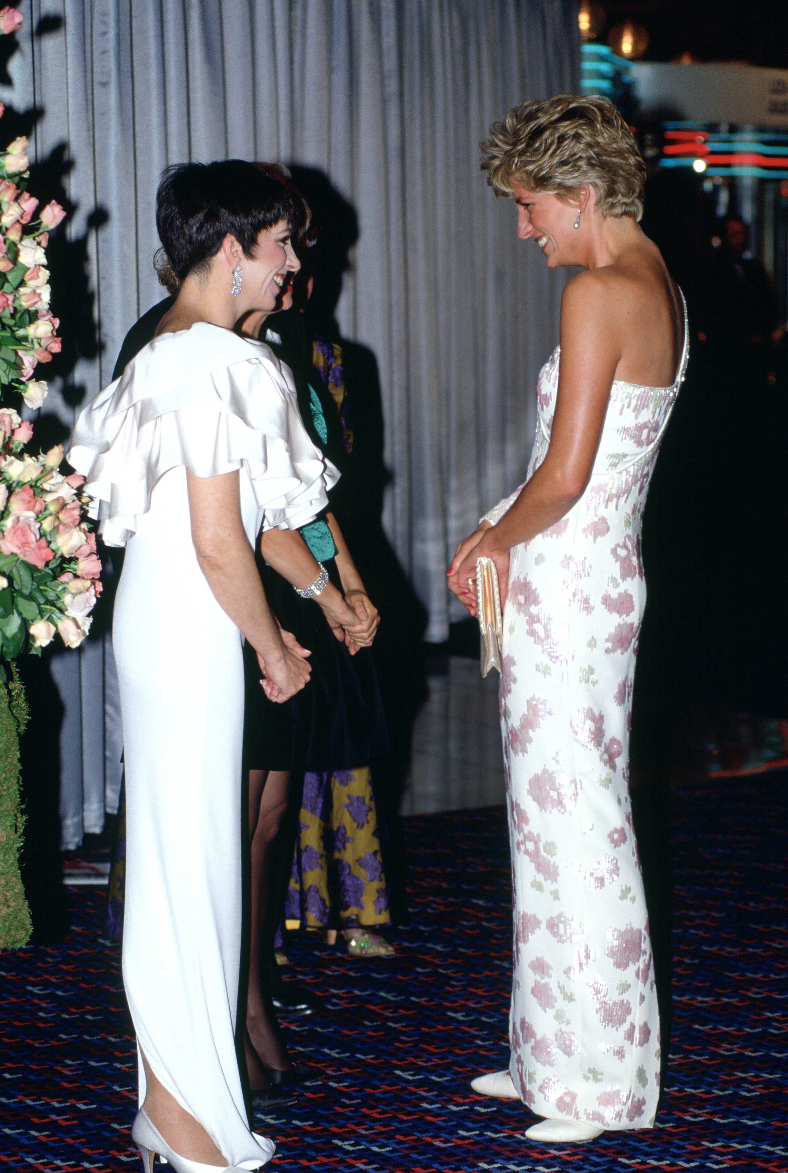 Princess Diana wearing a white gown talking to Liza Minelli at a film premiere