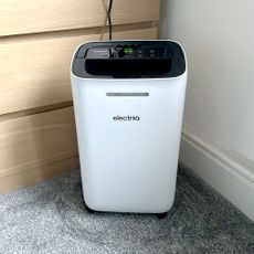 The ElectriQ 12L dehumidifier in a room with a grey carpet