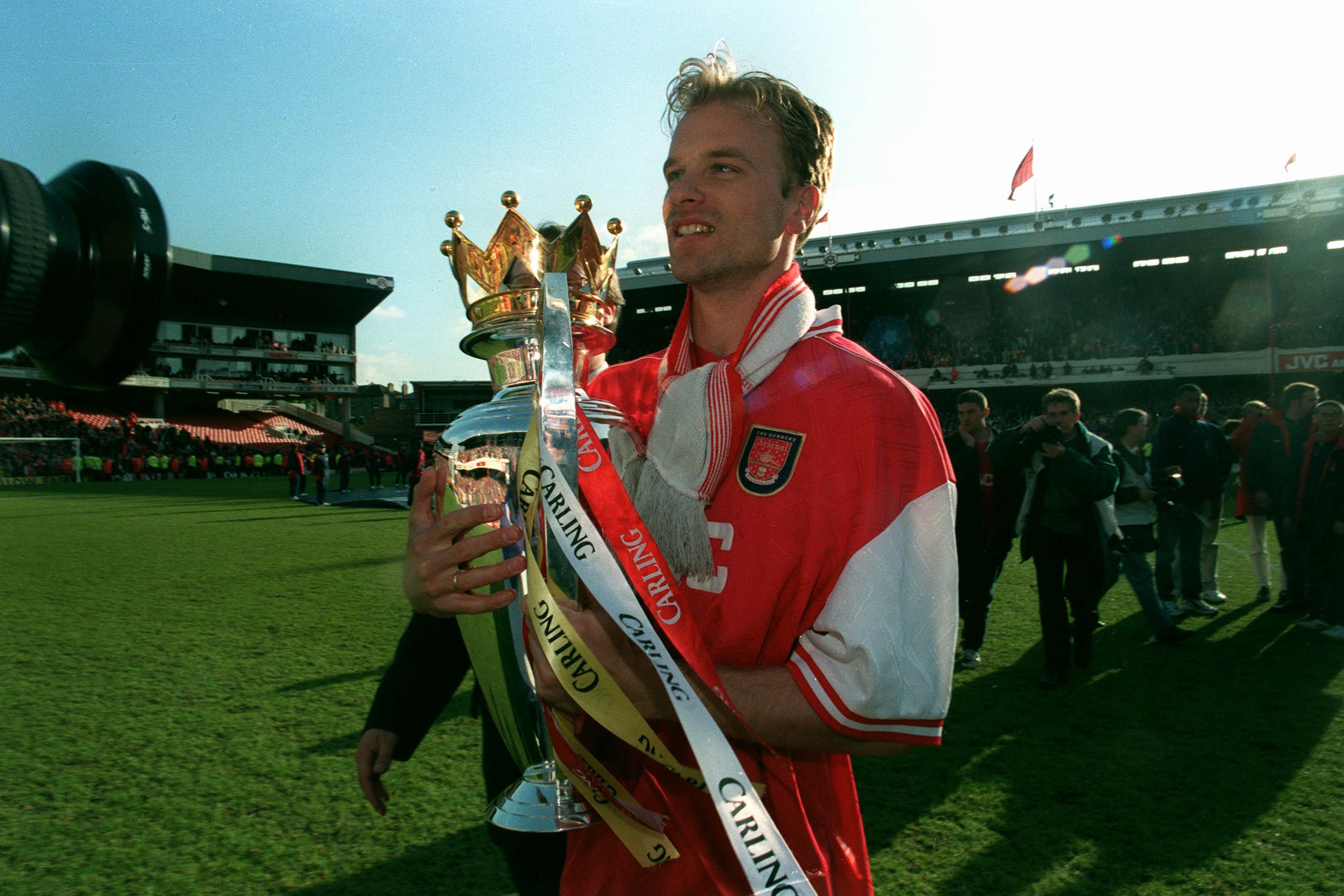 Dennis Bergkamp celebrates with the Premier League trophy after winning the 1997/98 title with Arsenal