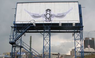 Painting on billboard by South African street-art troupe, Faith 47