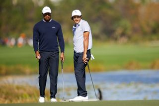 Tiger and Charlie Woods watch a putt