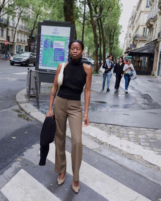 Instagram photo of Slyvie Mus in black top tan pants