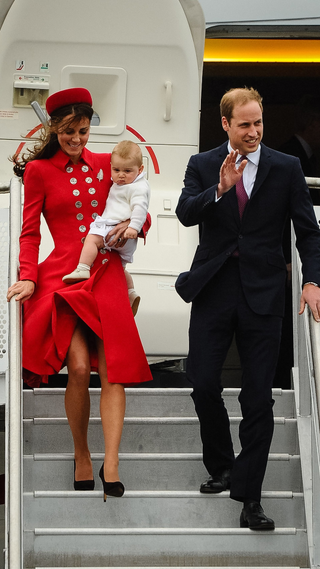 Britain's Prince William (R) and his wife Catherine, carrying baby Prince George, wave upon their arrival at the international airport in Wellington on April 7, 2014. William, Kate and their son Prince George are on a three-week tour of New Zealand and Australia