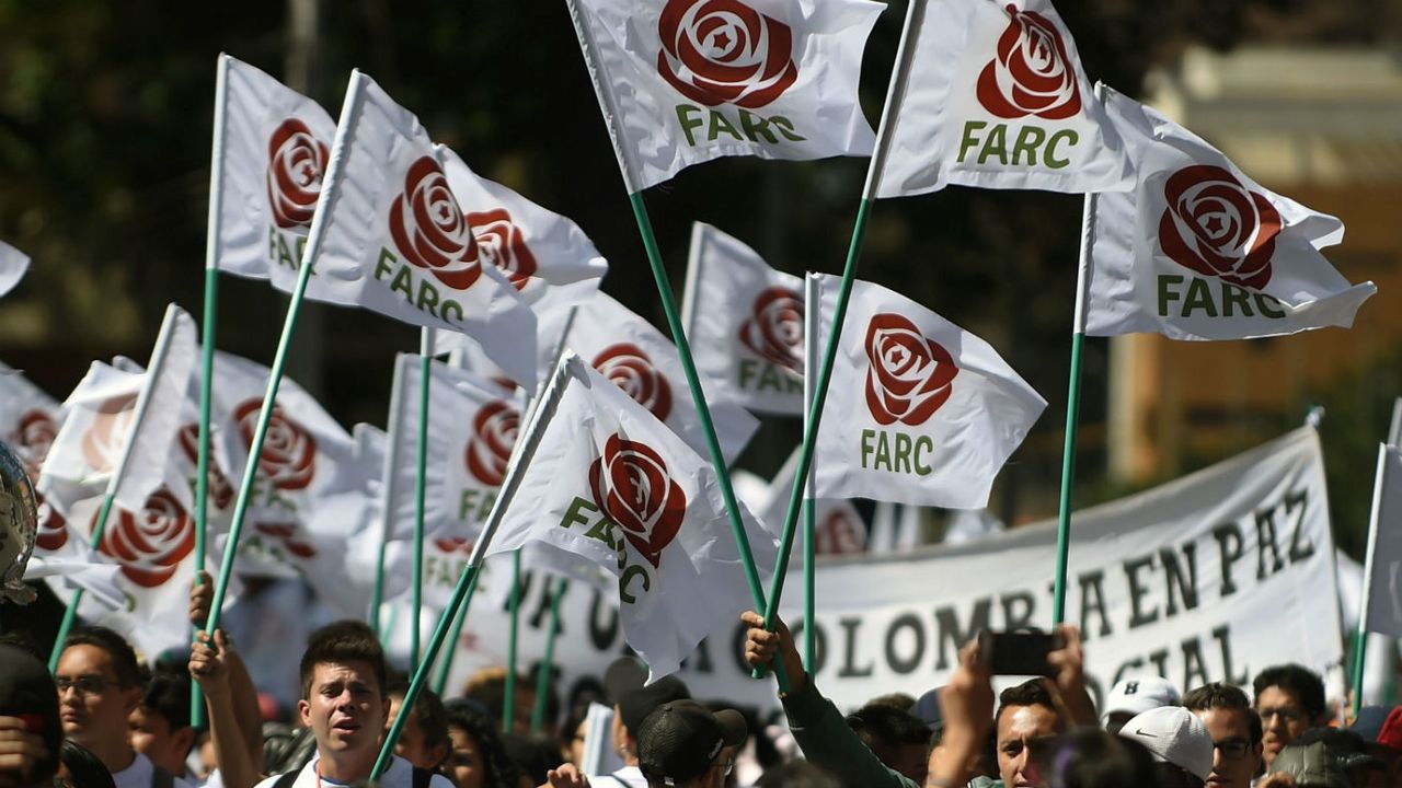 Farc members and supporters wave flags bearing the movement&amp;#039;s new logo at its first conference as a political party