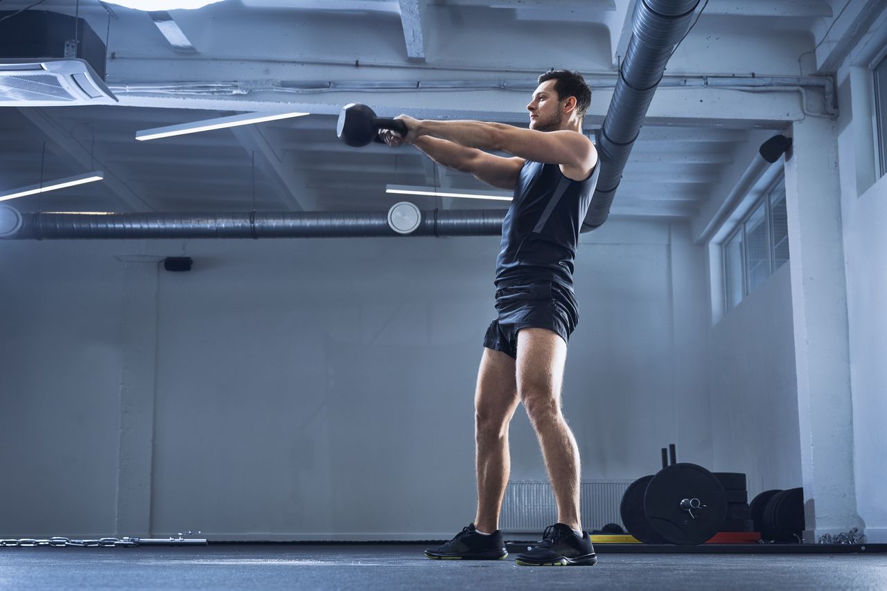 A man performing kettlebell swings