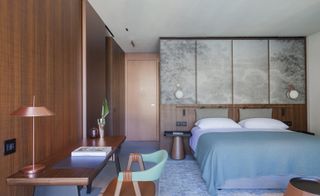 Bedroom in earth tones with wood-panelled walls and desk with chair