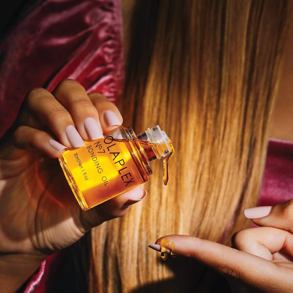 olaplex deals: woman dropping bonding oil onto her finger