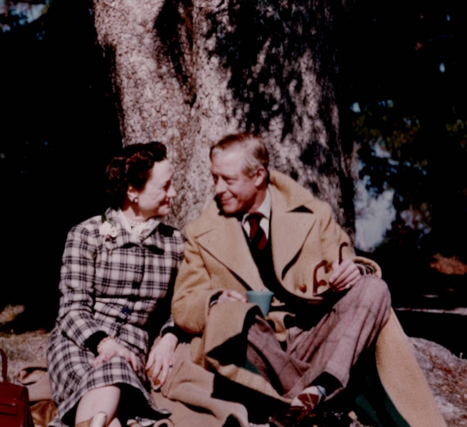 The Duchess and Duke of Windsor sitting on the ground, against a tree