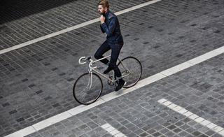 A man is cycling in the middle of the road