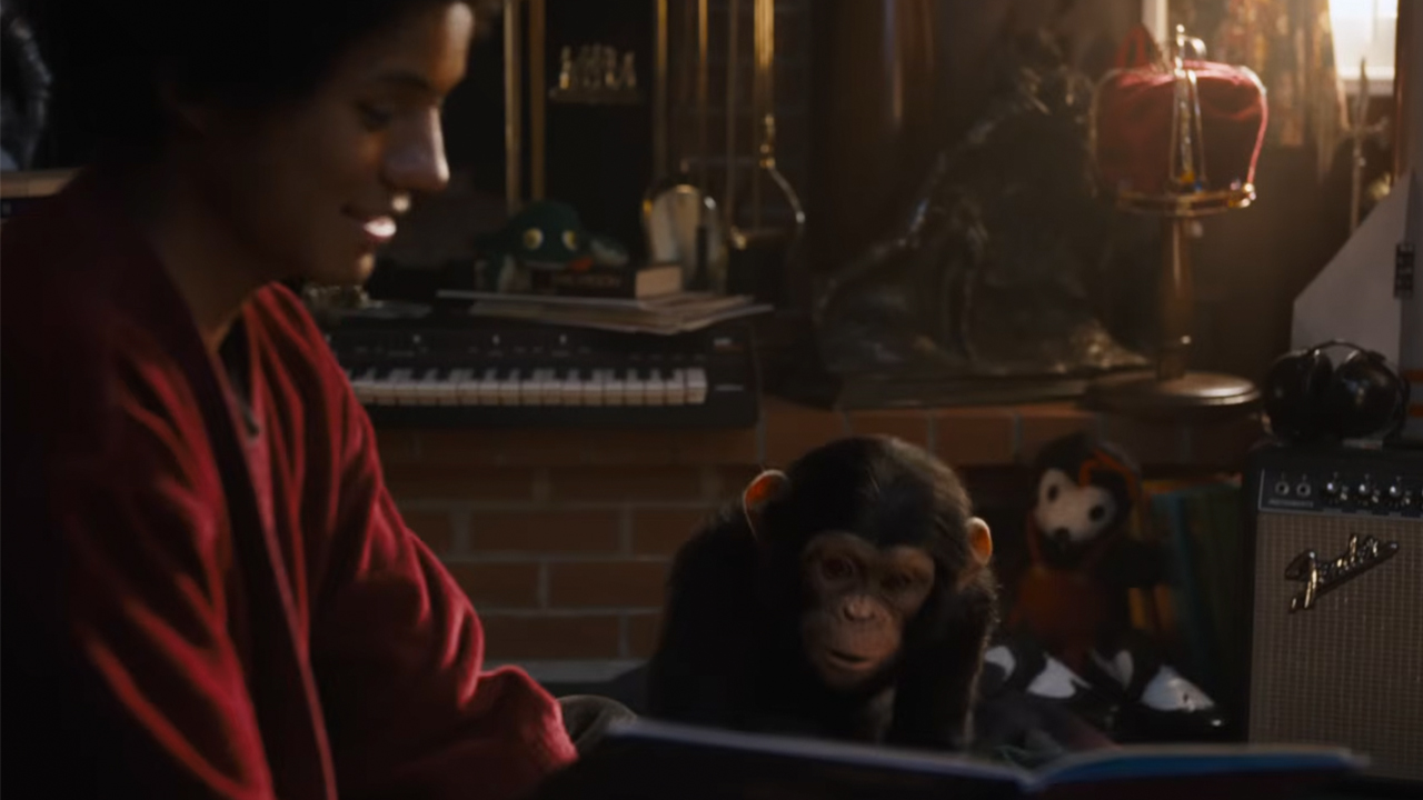 Jafaar Jackson as Michael Jackson pointing to a book and smile with Bubbles in the chimp in Michael.