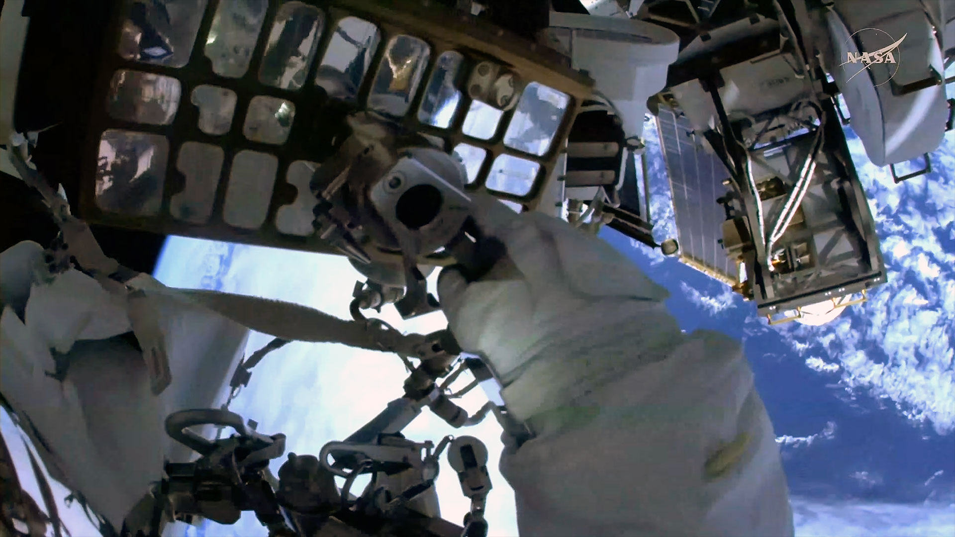 An astronaut's glove is seen from a helmet mounted camera during a spacewalk outside a space station in Earth orbit