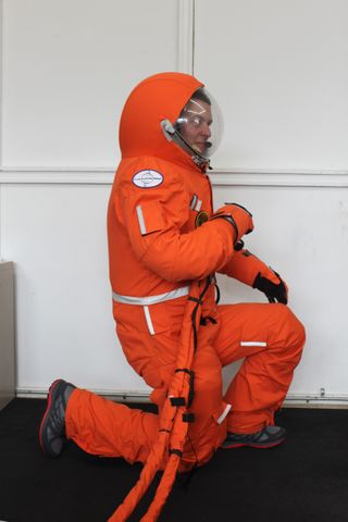 Final Frontier Design's Ted Southern kneels in the third version of his spacesuit.