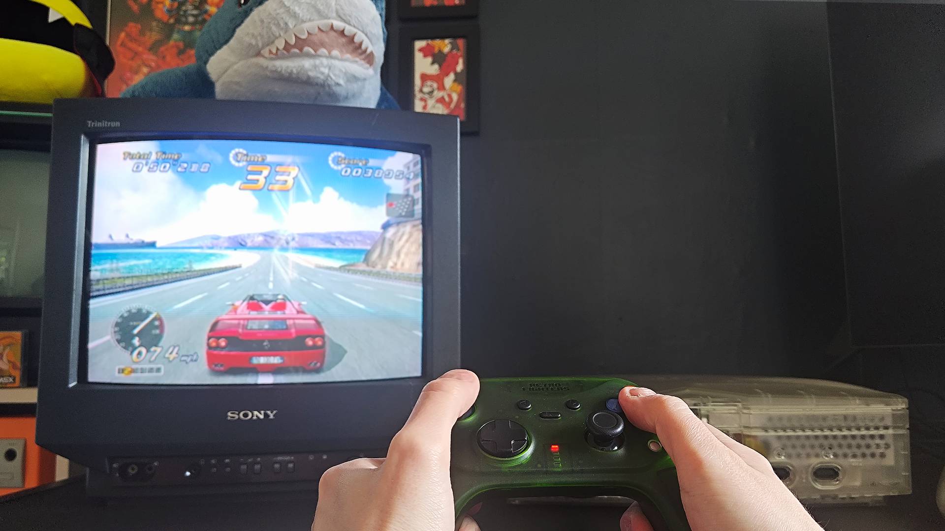 Retro Fighters Hunter Being used to play Outrun 2 on OG Xbox with red Ferrari on road.