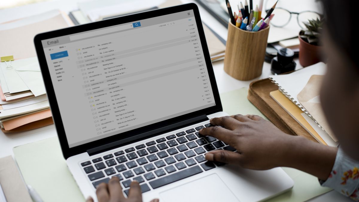 Person checking email inbox while sitting at a desk