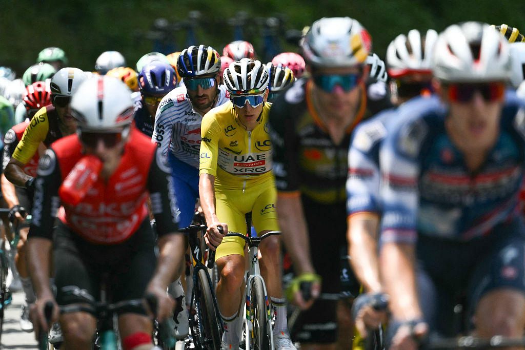 UAE Team Emirates - XRG team's Slovenian rider Tadej Pogacar wearing the overall leader's yellow jersey cycles with the pack of riders (peloton) during the 10th stage of the 112th edition of the Tour de France cycling race, 165.3 km between Ennezat and Le Mont-Dore Puy de Sancy, in central France, on July 14, 2025. (Photo by Marco BERTORELLO / AFP)