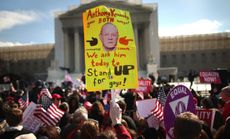 A sign depicting Justice Anthony Kennedy is housed outside the Supreme Court on March 27.