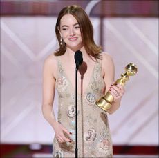 emma stone accepts an award at the golden globes