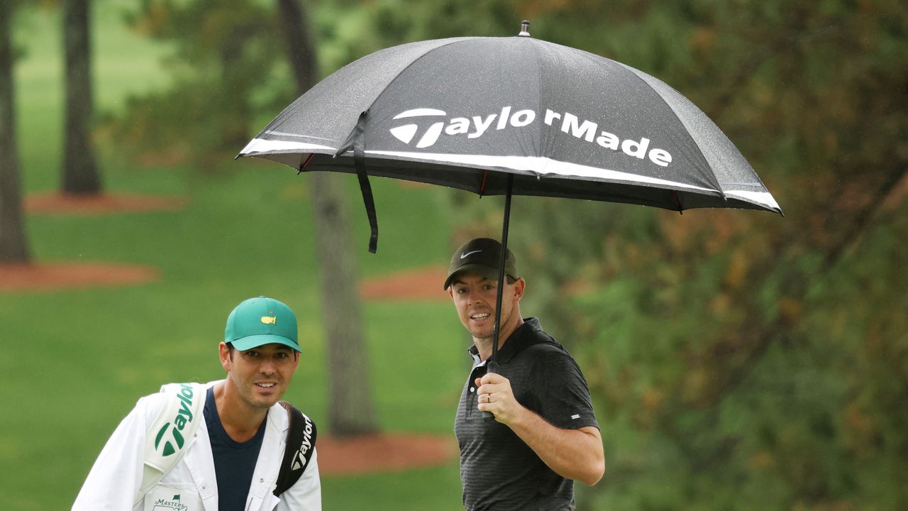 Rory McIlroy holds an umbrella