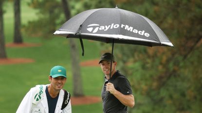 Rory McIlroy holds an umbrella