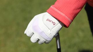 The Ping Sport Ladies Glove holding a golf club