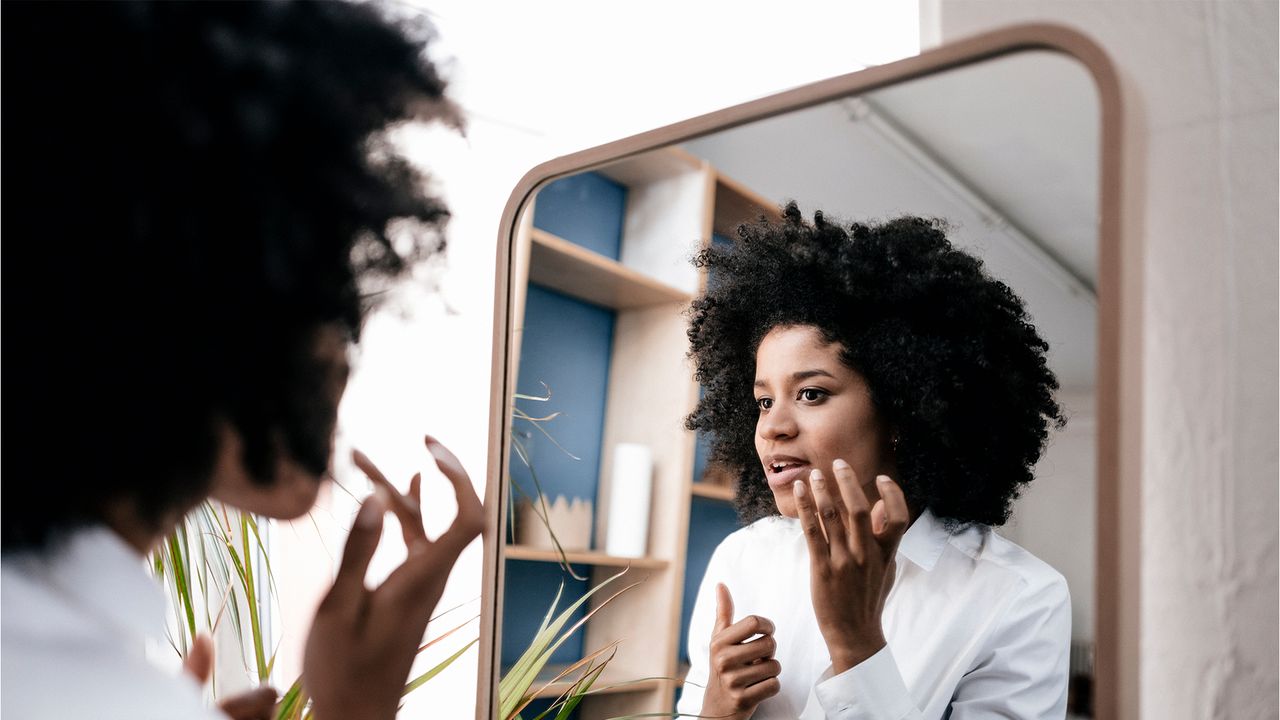 Young woman applying lip care - stock photo