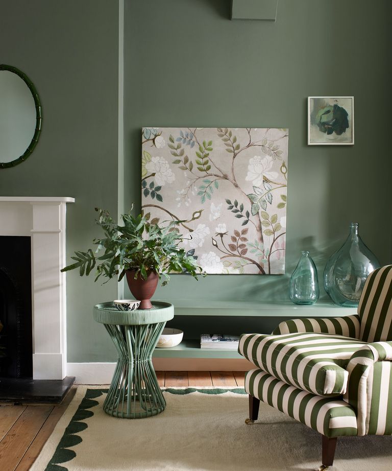green living room with green stripe armchair botanical print and low shelf storage