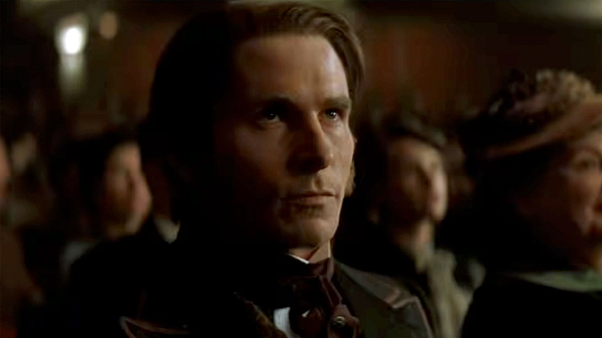 Christian Bale looking up with concern while sitting in a theater in The Prestige.