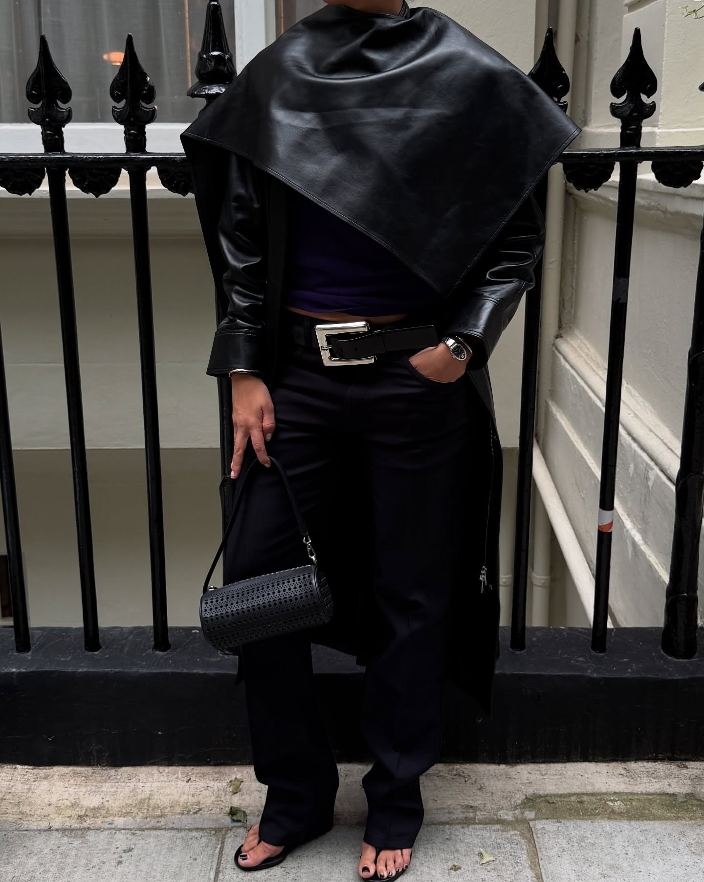 Influencer wearing scarf neckline trend top in black leather.