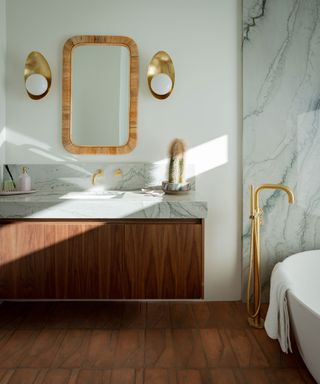 Modern bathroom, dark wood cabinetry, wicker mirror, brass wall lights