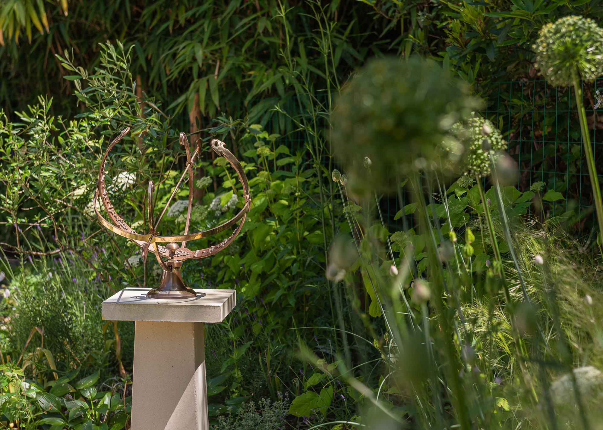 a metal garden sculpture circular shape on a pedestal