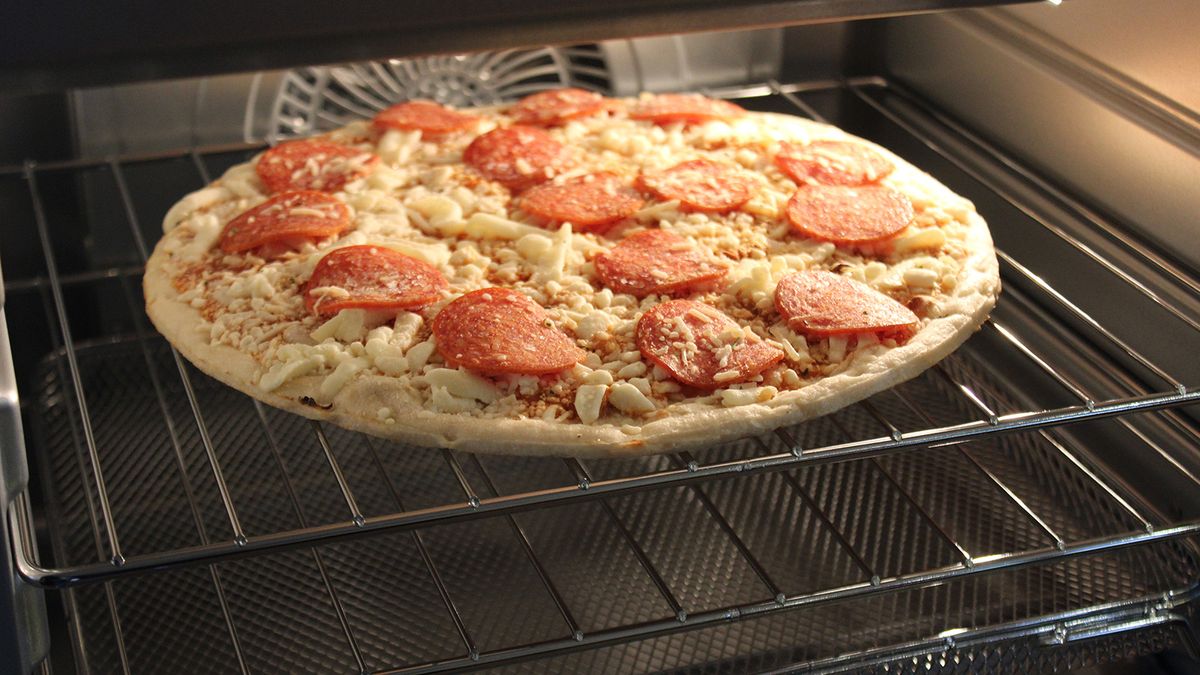Ninja Prestige Smart XL Air Fryer &amp; Countertop Oven cooking a frozen pizza
