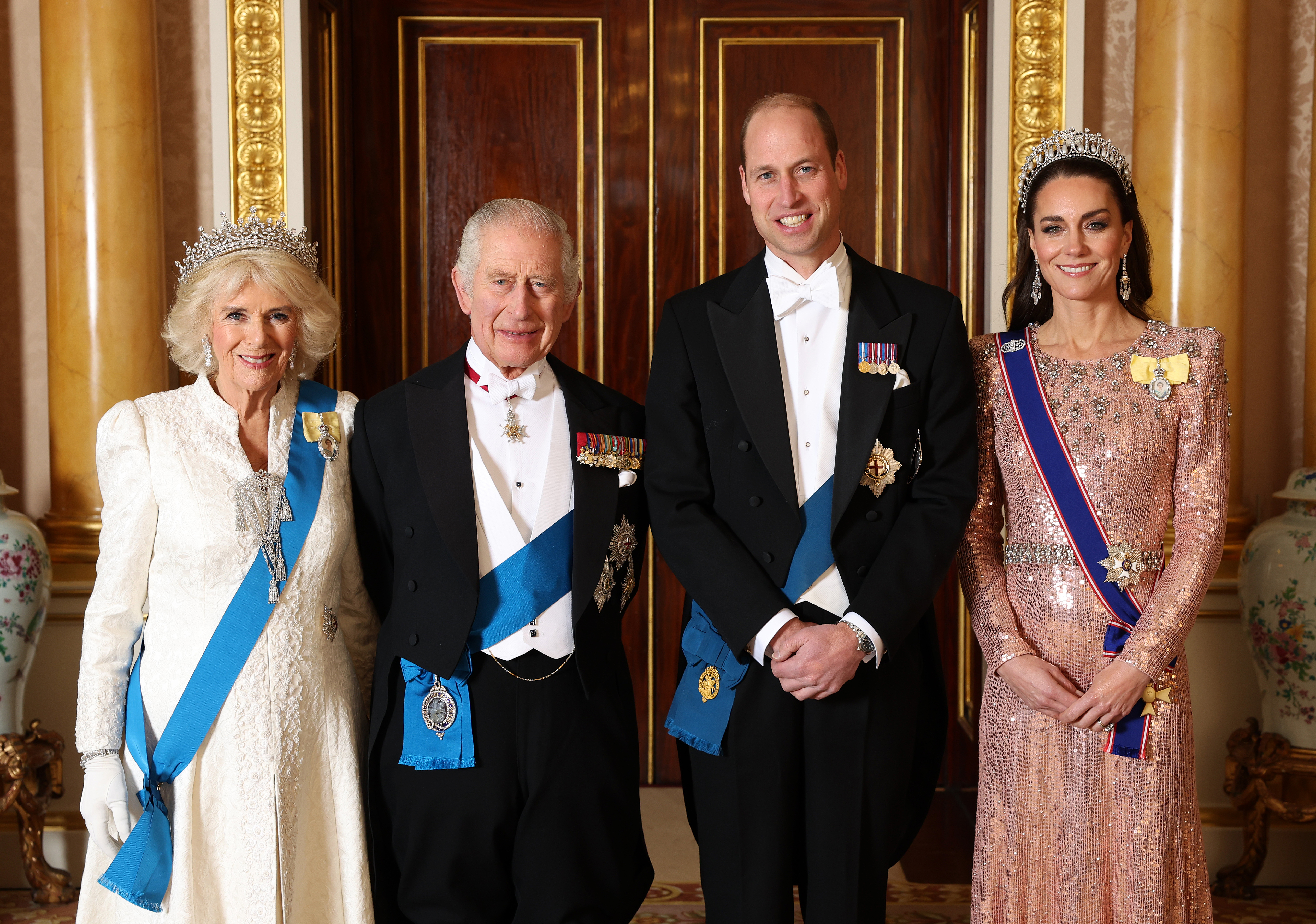 Queen Camilla, King Charles, Prince William and Princess Kate wearing gowns and tuxes and tiaras