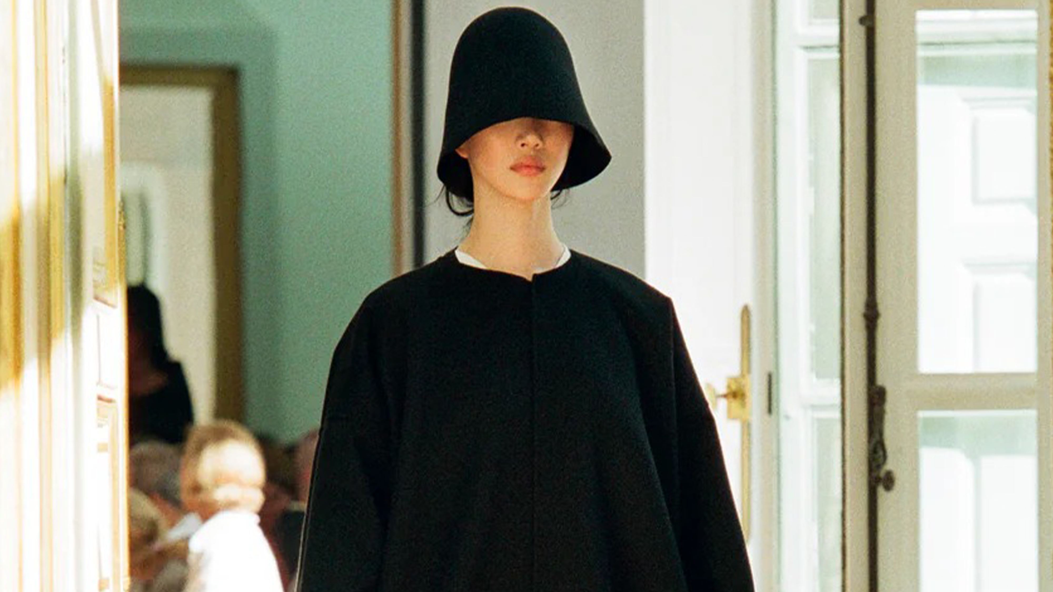 Model from The Row wears black wool bucket hat from Spring Summer 2024 collection.