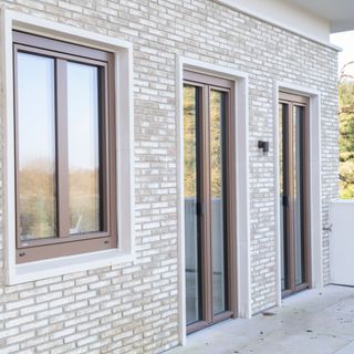 modern brown frame windows in brick house