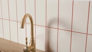 cream rectangular kitchen tiles with brass kitchen tap