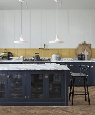 two white pendant lights over a marble kitchen island