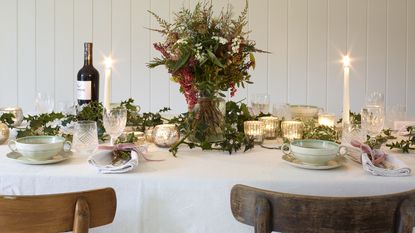 dining room with white wood panel walls and table set for christmas dinner