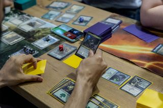 Participants play a Magic: The Gathering card game during a weekly tournament at the Uncommons hobby shop in New York, U.S., on Thursday, June 27, 2019. In the battle for gaming dominance, Hasbro Inc. has what it hopes is an ace up its sleevein a deck of playing cards that hit the market 26 years ago. 