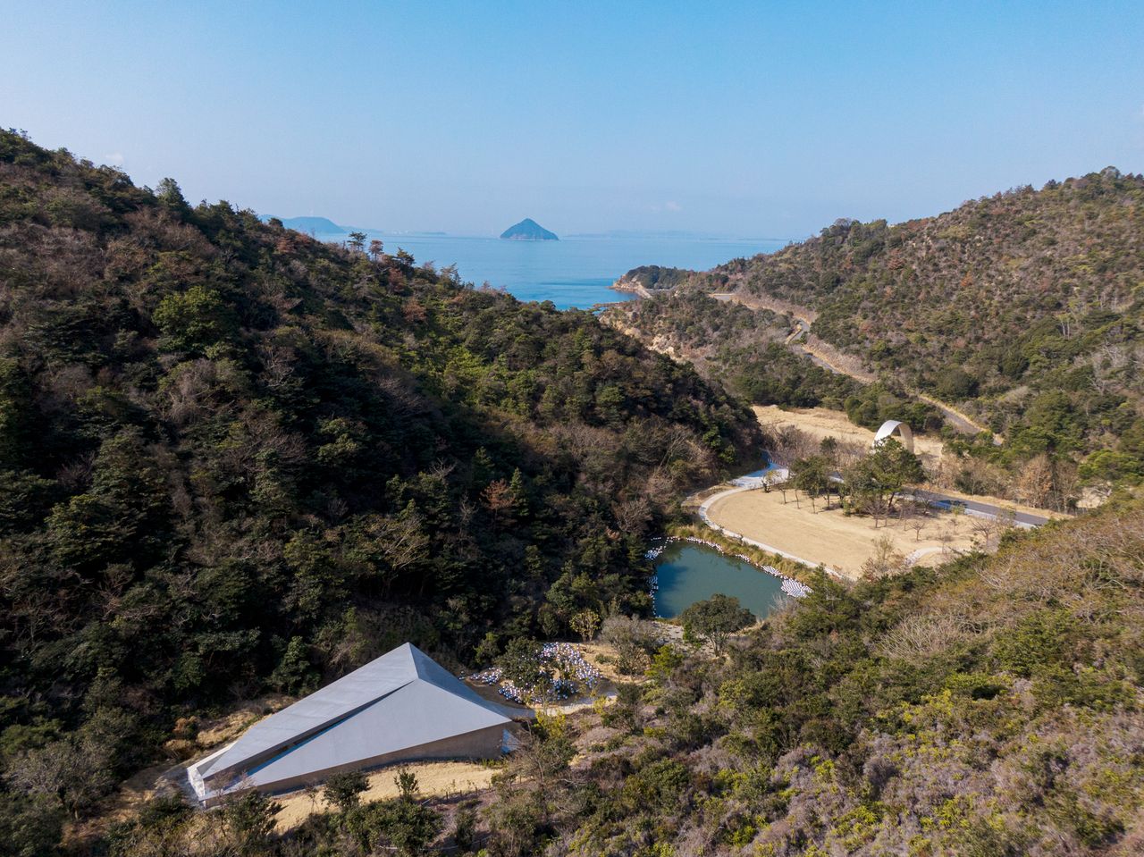 Tadao ando&#039;s valley gallery in Naoshima, seen from above among its green surrounds