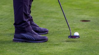 A golfer wears the Puma DRYLBL Golf Boots and hits a putt