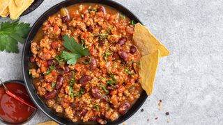 Beef chili in large bowl with tortilla chips