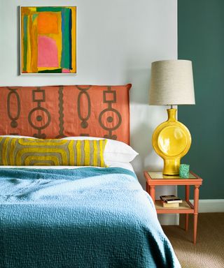 colorful bedroom with bed, large yellow table lamp and bedside table