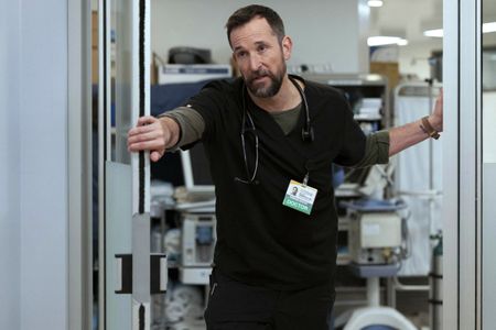Actor Noah Wyle plays Dr. Michael "Robby" Robinovitch on the hit TV series The Pitt. He is in his scrubs in the ER.